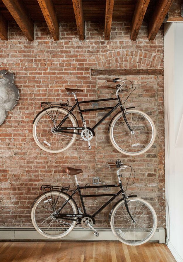 Vélos accrochés sur un mur en brique.